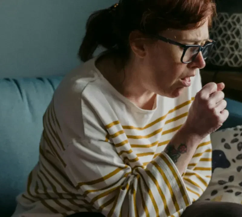 woman coughing in home